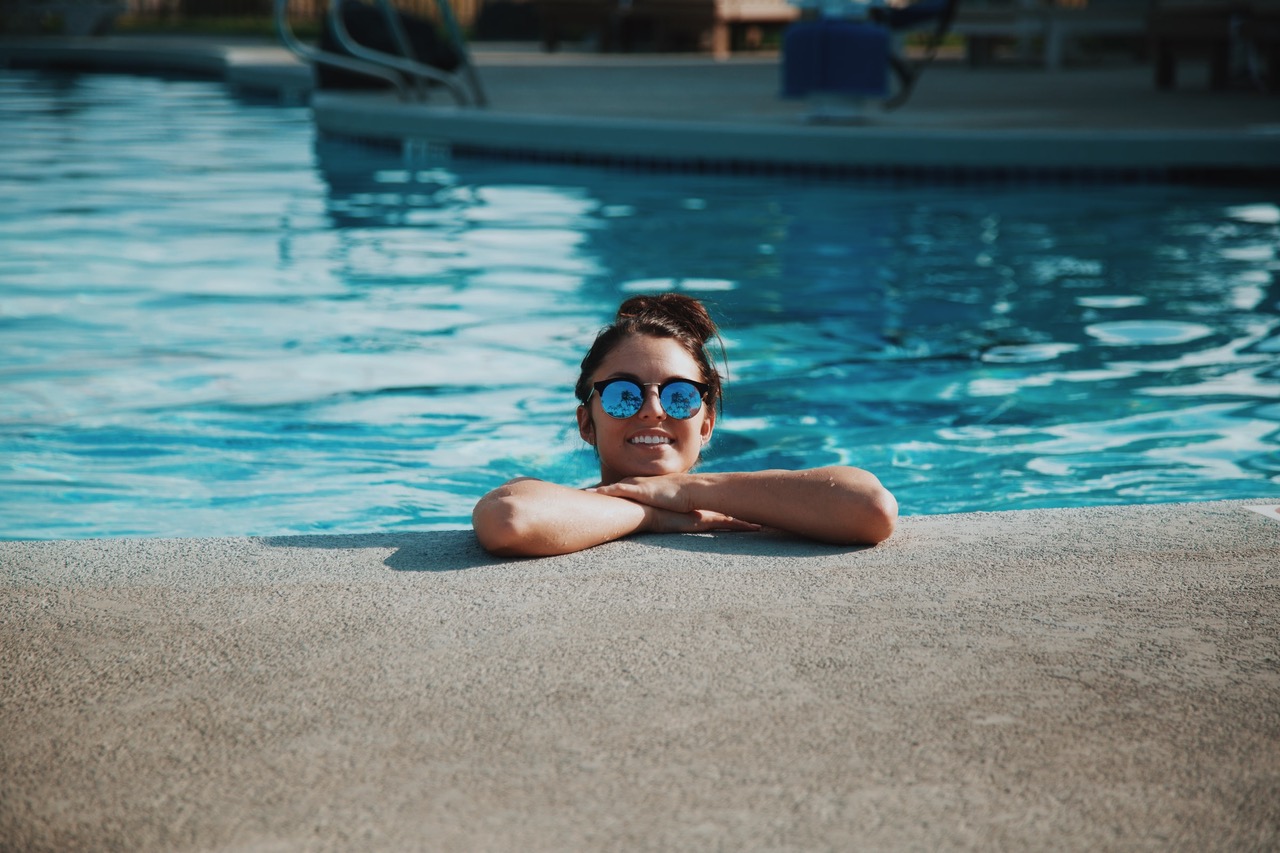 Woman relaxing at the edge of a heated swimming pool